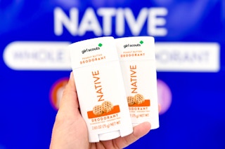 hand holding 2 native deodorants in front of signage at target
