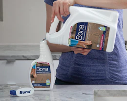 a person refilling a spray bottle with cleaner