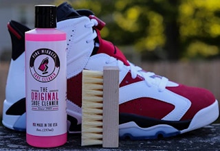 pink shoe cleaner bottle and brush in front of a shoe