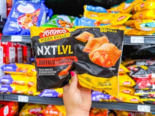 hand holding a bag of totinos pizza rolls in walmart frozen section