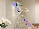 a person using a spin scrubber to clean a shower stall 