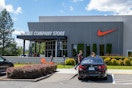 The exterior of a Nike Company Store with people walking outside