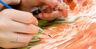 A person painting a paint by numbers