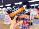 hand holding two packages of duracell batteries in office depot