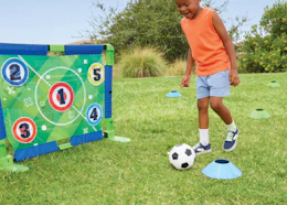 a little kid playing with a soccer set outside