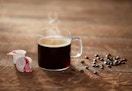 cup of coffee beside creamers