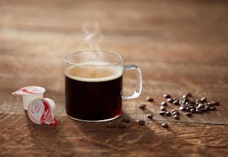 cup of coffee beside creamers
