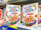 hand touching a box of cinnamon toast crunch cereal at dollar general