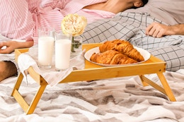 Pipishell Bamboo Bed Tray Table on a bed with food on it.