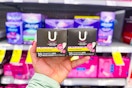 person holding 2 boxes of pantyliners