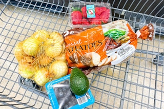 fresh onions, potatoes, bluberries, avocado, strawberries in a shopping cart