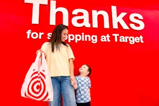 a woman and child standing in front of a big sign at target