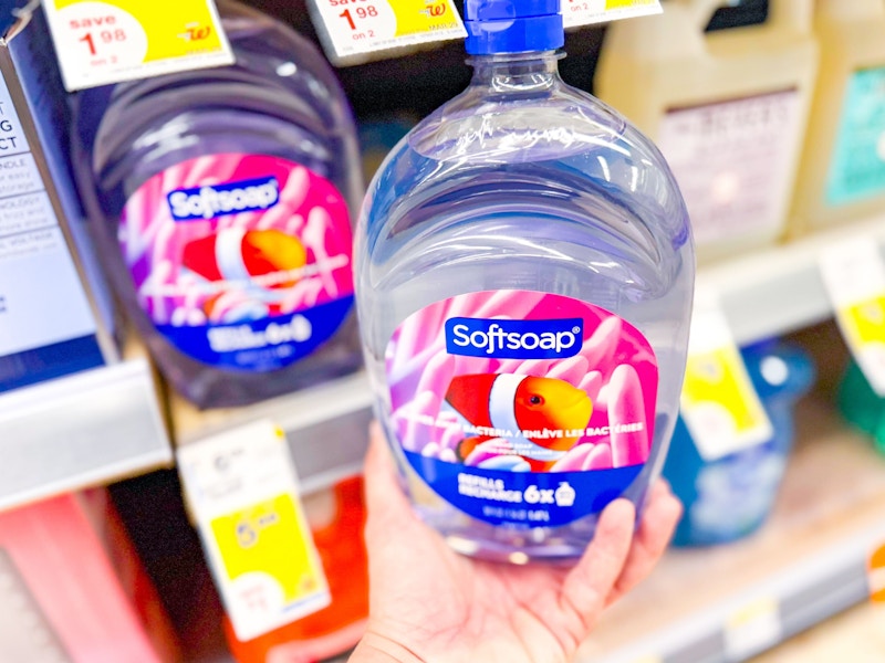 person holding a softsoap refill by the shelf