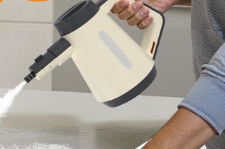 a person using a handheld steamer
