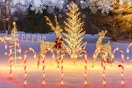 BUCASA 12 Pack Christmas Decorations Outdoor Solar Candy Cane Lights outside a house in the snow.