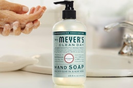 person washing their hands next to handsoap