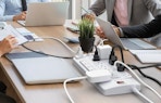 devices plugged into an power strip on a table 