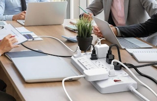 devices plugged into an power strip on a table 