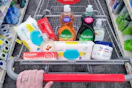 person pushing a cart with pampers wipes, colgate toothpaste, cvs beauty soap, palmolive dish soap, and aquaphor ointment in it