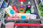 person pushing a cart with pampers wipes, colgate toothpaste, cvs beauty soap, palmolive dish soap, and aquaphor ointment in it