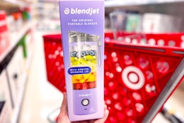 hand holding a blendjet portable blender in front of target cart