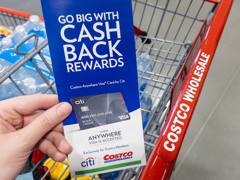 A person holding a pamphlet for information on a Costco Credit card