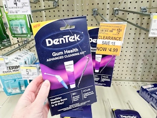 person holding a gum health cleaning kit by a $4.99 clearance sign