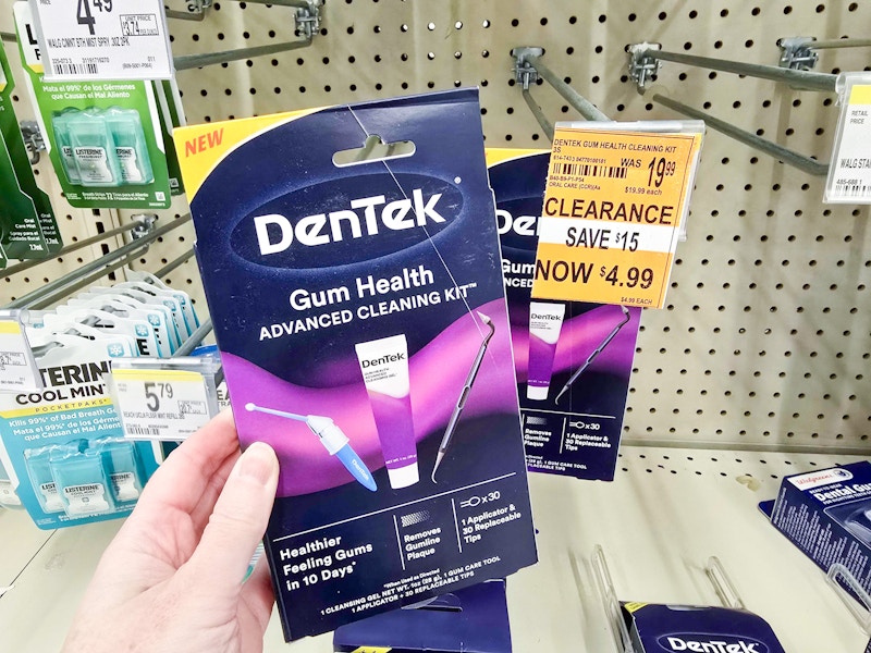 person holding a gum health cleaning kit by a $4.99 clearance sign