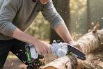 a person using a chainsaw on a log