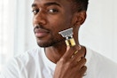 a man using a beard trimmer on his face