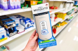 hand holding a thermacell mosquito repeller in front of target shelves