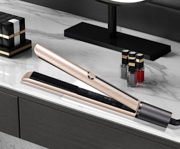 a rose gold hair straightener on a bathroom counter