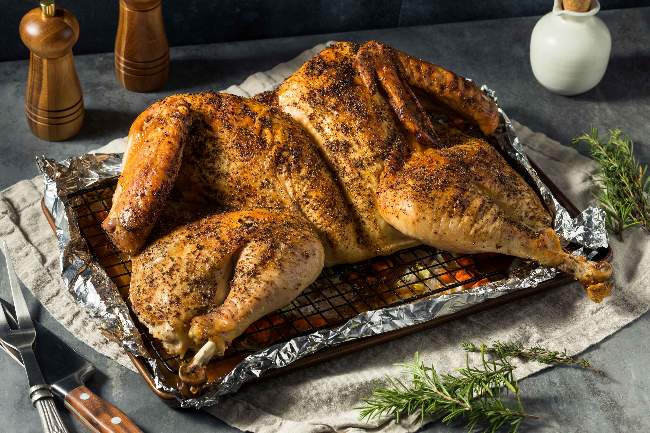 A spatchcocked turkey in a pan on a table.