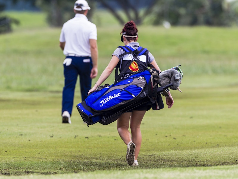 a golf caddy carrying someones golf clubs