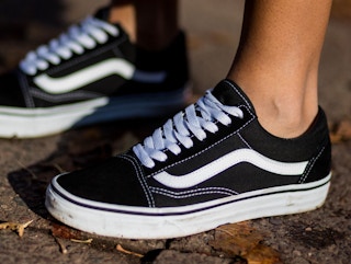 someone wearing black and white vans