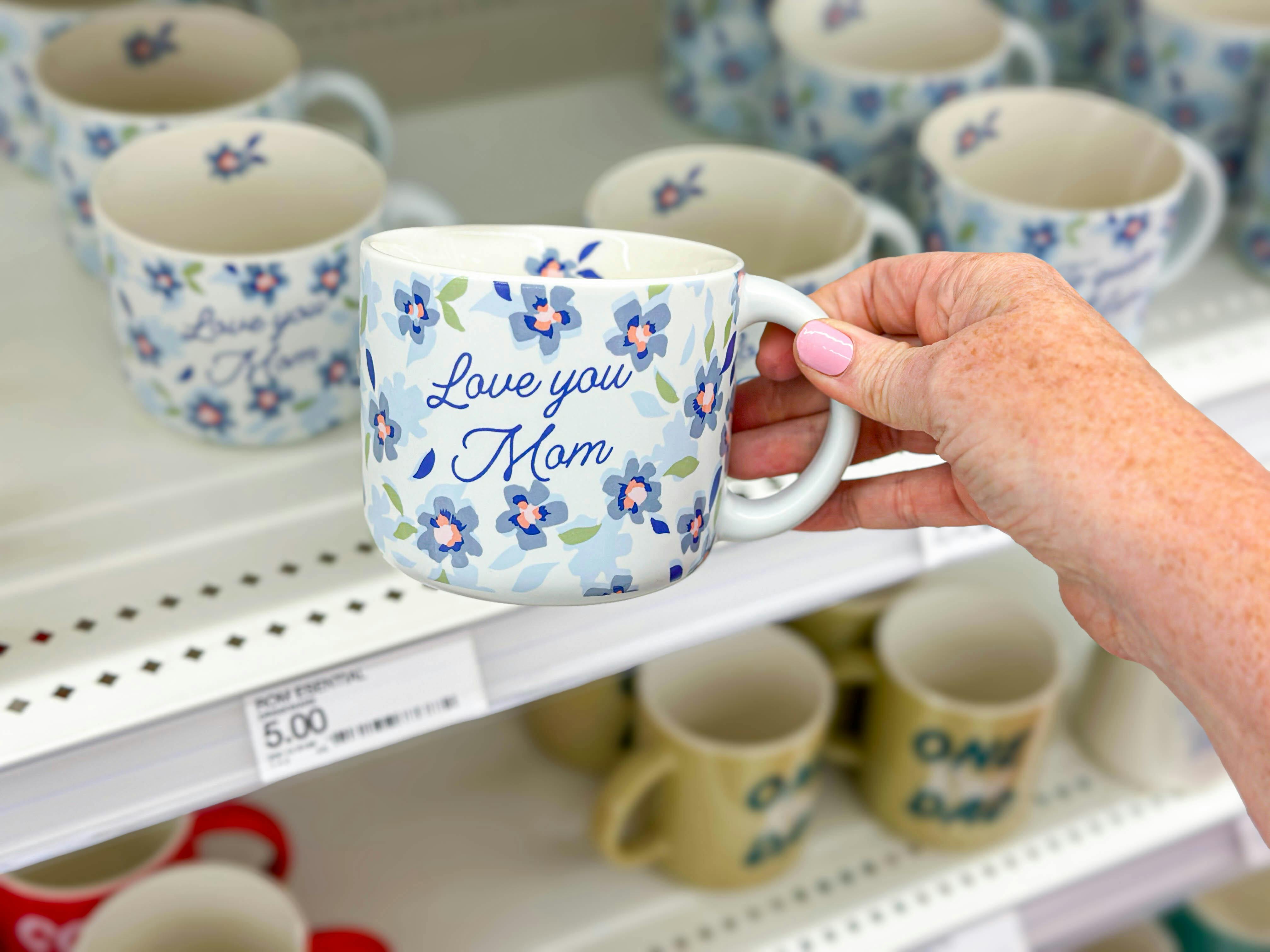 hand holding an i love you mom mug in front of a target shelf