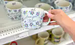 hand holding an i love you mom mug in front of a target shelf