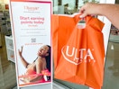 Someone holding an Ulta bag next to a sign for Ultamate Rewards inside an Ulta store
