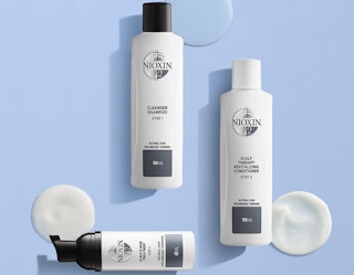 white and black hair care bottles on a blue background