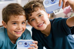 boys playing with an instant camera