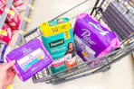 hand holding poise pads next to poise and depend products sponsored
