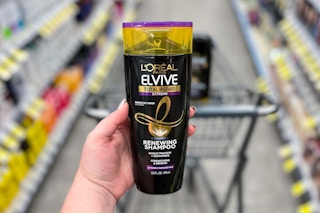 hand holding bottle of shampoo in drugstore aisle