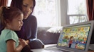 A child and parent looking at ABCmouse on a computer. 