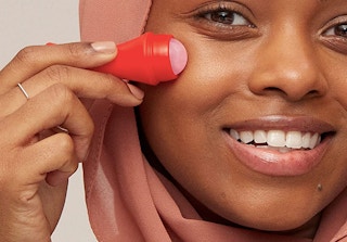 smiling person using the revlon quartz roller on face