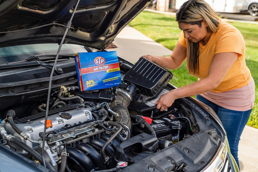 a woman putting a filter in a car