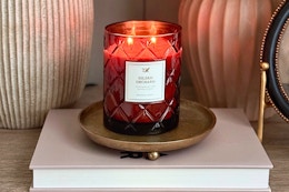 Lifestyle image of the My Texas House Gilded 2-wick candle on book