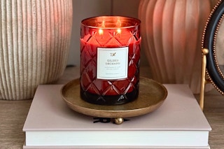 Lifestyle image of the My Texas House Gilded 2-wick candle on book