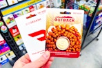 hand holding doordash and outback gift cards