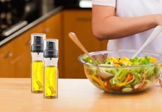 two glass sprayers on a counter with a salad