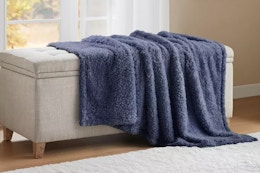 a blue throw blanket on an ottoman